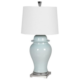 Curved dusty blue porcelain lamp with natural linen shade, styled on a console table. Available from Lily Bloom in-store or online.