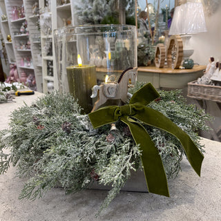 Collette’s Winter Hurricane Glass Centre with greenery, sage LED candle and green velvet bow. Buy online at www.lilybloom.ie.”