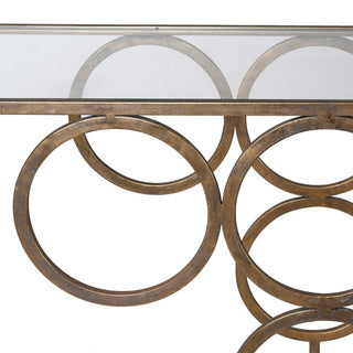 The Paloma Console Table – gold metal frame with looped-circle base and clear glass top, available at Lily Bloom, Gorey, Ireland.